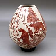 A red on white jar decorated with a sgraffito wildlife and nature design
 by Leonel Lopez Sr of Mata Ortiz and Casas Grandes