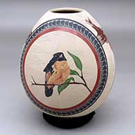 A polychrome jar decorated with a sgraffito and painted bird, branch leaf and geometric design
 by Jesus Trevizo of Mata Ortiz and Casas Grandes