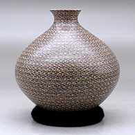 A polychrome jar with a tiny flared opening and decorated all over with bands of tiny geometric design, click or tap to see a larger version