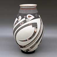 A tall polychrome jar decorated with a lightly carved and painted three panel sickle, serpent, tiny square and geometric design
 by Tavo Silveira of Mata Ortiz and Casas Grandes