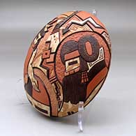 A polychrome mixed clay seed pot decorated on top with a carved, sgraffito and painted masked dancers and geometric design, click or tap to see a larger version