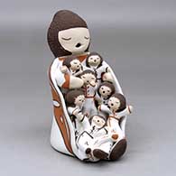 A sitting grandmother storyteller figure wearing a manta with seven children
 by Chris Teller of Isleta