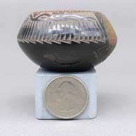 Miniature black bowl with a sienna rim and a sgraffito koshare, pueblo, avanyu, feather ring, bear paw, and geometric design, click or tap to see a larger version