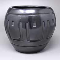 A black jar carved with an eight-panel geometric design around the body
 by Elizabeth Naranjo of Santa Clara