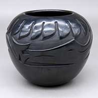 A black jar carved with a ring-of-feathers and an avanyu design around and above the shoulder
 by Glenda Naranjo of Santa Clara