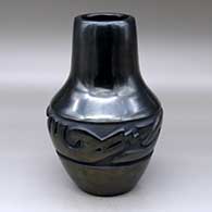 A tall black vase decorated with a carved avanyu design below the shoulder
 by Lee Tafoya of Santa Clara