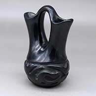 A black wedding vase carved with an avanyu and geometric design around the body
 by Helen Shupla of Santa Clara