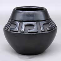 A black jar decorated with a band of geometric design carved above the shoulder
 by Mary Singer of Santa Clara