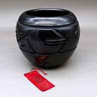 A large black jar carved with a stylized avanyu design around the shoulder, Second Place ribbon from Gallup Intertribal Ceremonial
 by Betty Tafoya of Santa Clara