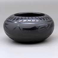 A black on black bowl decorated around the body with a plumed avanyu, ring of feathers, cloud formation and geometric design
 by Marvin and Frances Martinez of San Ildefonso