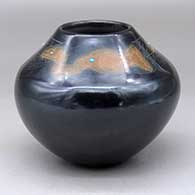 A black jar with sienna spots and inlaid stones, decorated above the shoulder with a sgraffito avanyu, feather, fineline and geometric design
 by Barbara Gonzales of San Ildefonso