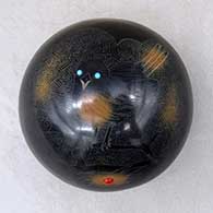 A black seed pot with sienna spots, inlaid stones and a sgraffito chickadee, branch, pine needles and geometric design
 by Barbara Gonzales of San Ildefonso