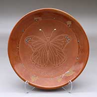 A red and micaceous red shallow bowl decorated with inlaid stones and a sgraffito butterfly and geometric design
 by Barbara Gonzales of San Ildefonso