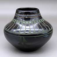 A green on black jar decorated with a feather design above the shoulder, a geometric design below and two strands of inlaid heishi beads around the neck
 by Erik Fender of San Ildefonso