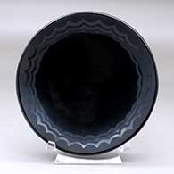 A black on black plate decorated with a geometric design
 by Maria Martinez of San Ildefonso