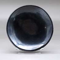 A plain, polished black plate
 by Maria Martinez of San Ildefonso