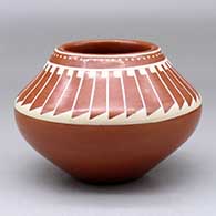 A buff on red bowl decorated with a ring of feathers design above the shoulder
 by Kathy Gutierrez of San Ildefonso