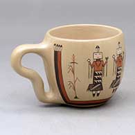 A polychrome cup with a handle, decorated around the outside with a corn stalk and yeibichai design
 by Ida Sahmie of Dineh