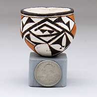 A miniature polychrome bowl decorated with a two-panel rain cloud and geometric design
 by Lucy Lewis of Acoma