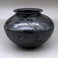 A black on black jar with a rolled lip and decorated with a three panel rosette and geometric design
 by Roberto Banuelos of Mata Ortiz and Casas Grandes