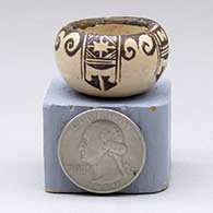 A miniature black-on-buff bowl decorated with a four-panel thunderbird and geometric design
 by Dextra of Hopi