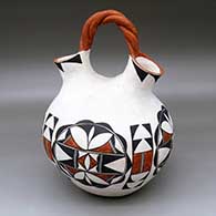 A polychrome wedding vase with a twisted bridge and decorated with a four-panel geometric design
 by Ruby Shroulote of Acoma
