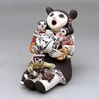 A sitting grandmother storyteller figure with three children, a pot and a turtle
 by Marilyn Ray of Acoma
