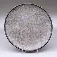 A black on white plate decorated with a snowflake fineline geometric design
 by Sarah Garcia of Acoma