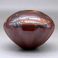 A polychrome jar with a melon base decorated above the shoulder with a three panel sgraffito and painted geometric design, click or tap to see a larger version