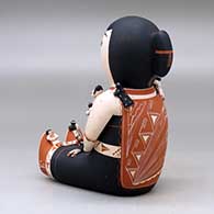 A sitting grandmother storyteller figure with 19 tiny children, click or tap to see a larger version