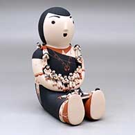 A sitting grandmother storyteller figure with 19 tiny children, click or tap to see a larger version