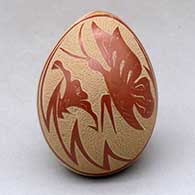 A polychrome ovoid seed pot decorated with a sgraffito butterfly, flower and geometric design
 by Vangie Tafoya of Jemez