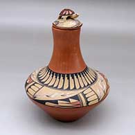A lidded tall necked polychrome jar decorated with a geometric design above the shoulder and a turtle on the lid
 by Vangie Tafoya of Jemez