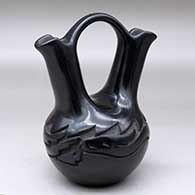A black wedding vase carved with an avanyu design around the shoulder
 by Chris Martinez of Santa Clara