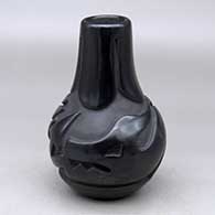 A black wedding vase decorated with a ring of feathers carved around the neck and an avanyu design carved around the shoulder
 by Madeline Naranjo of Santa Clara