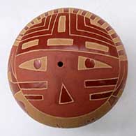 A red seed pot decorated with a sgraffito sunface, hummingbird, flower, feather and geometric design
 by Camilio Tafoya of Santa Clara