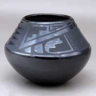 A black on black jar decorated above the shoulder with a four-panel bat wing and geometric design
 by Maria Martinez of San Ildefonso