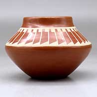 A buff on red jar decorated with a band of feathers geometric design above the shoulder, click or tap to see a larger version