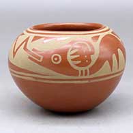 A buff on red jar decorated with an avanyu and geometric design above the shoulder
 by Angelita Atencio Sanchez of San Ildefonso