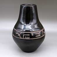 A large black jar carved with a stylized avanyu design around the shoulder
 by Richard Ebelacker of Santa Clara