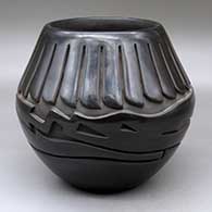 A black jar carved around the body with an avanyu and ring of feathers design
 by Vickie Martinez of Santa Clara