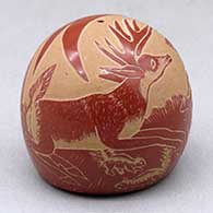 A miniature red seed pot decorated with a sgraffito stag, skunk and geometric design
 by Camilio Tafoya of Santa Clara