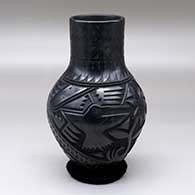 A black vase decorated with a carved and sgraffito hummingbird, roadrunner, serpent, feather and geometric design
 by Martin Olivas of Mata Ortiz and Casas Grandes