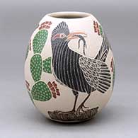 A polychrome jar decorated with a two panel sgraffito and painted roadrunner and prickly pear cactus design
 by Guadalupe Melendez of Mata Ortiz and Casas Grandes