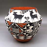 A large polychrome jar decorated with a three panel geometric design below the shoulder and a six panel deer and geometric design above the shoulder
 by Goldie Hayah of Acoma