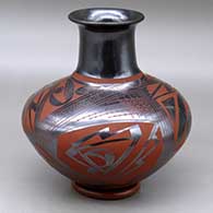 A red on glossy black jar with a tall and recurved neck, and decorated with a two panel bird element, sickle and geometric design
 by Unknown of Mata Ortiz and Casas Grandes