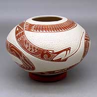 A red on white jar decorated with a lightly carved, sgraffito and painted serpent and geometric design
 by Eduardo Quintana of Mata Ortiz and Casas Grandes