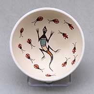A small polychrome bowl decorated on the outside with a two panel fineline and geometric design, and on the inside with a lady bug, lizard and geometric design
 by Sharon Lewis of Acoma