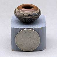 A miniature black bowl with a sienna rim and decorated with a sgraffito avanyu and geometric design
 by Geri Naranjo of Santa Clara