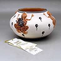 A polychrome bowl decorated with frog appliques and painted with a frog, tadpole and geometric design, Third Place ribbon from the 2003 Gallup InterTribal Ceremonial
 by Eileen Yatsattie of Zuni
